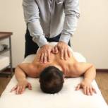 Chiropractor adjusting a patient on a table, showcasing proper alignment and limb positioning.